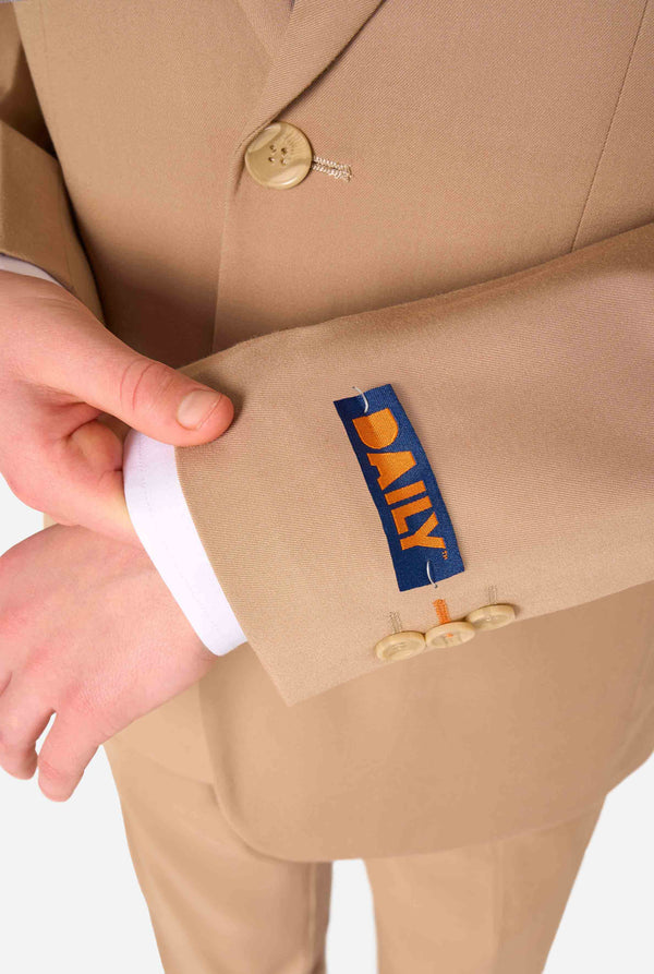 Tienerjongen draagt ​​een stijlvol lichtbruin/beige pak met een wit overhemd. Perfecte formele outfit voor speciale gelegenheden, bruiloften en feesten voor jongens. Close up van de mouwen.