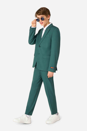Tienerjongen draagt ​​een stijlvol donkergroen pak met een wit overhemd en glimlacht zelfverzekerd. Perfecte formele outfit voor speciale gelegenheden, bruiloften en feesten voor jongens. Volledig lichaamsbeeld en jongen die een zonnebril draagt.