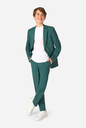 Tienerjongen draagt ​​een stijlvol donkergroen pak met een wit overhemd en glimlacht zelfverzekerd. Perfecte formele outfit voor speciale gelegenheden, bruiloften en feesten voor jongens. Volledig lichaamsbeeld.