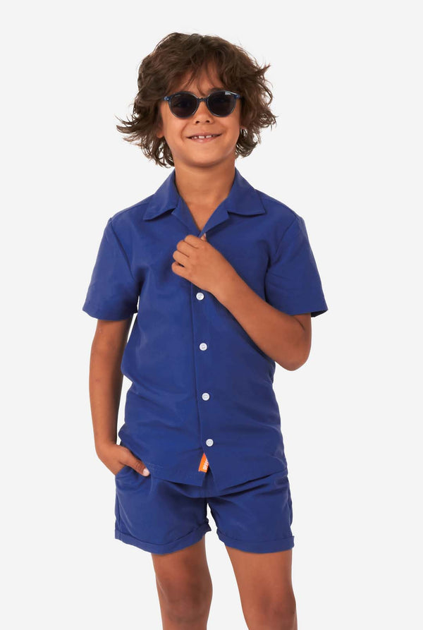 Jongen in donkerblauwe zomerset, bestaande uit korte broek en shirt