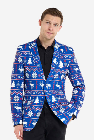 Man met blauwe kerstblazer voor mannen met Noordse kerstfiguren. Man draagt ​​ook een zwarte broek en een zwart herenoverhemd.