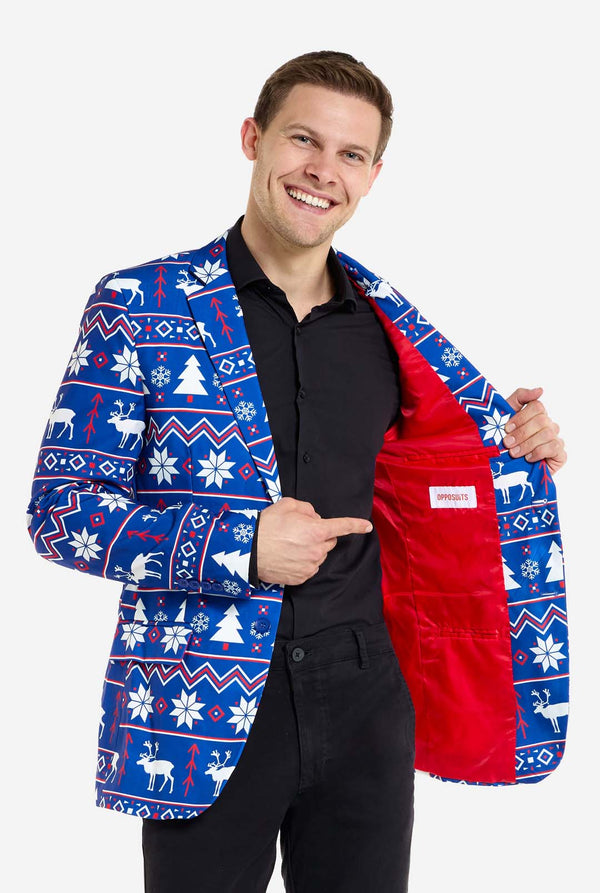 Man met blauwe kerstblazer voor mannen met Noordse kerstfiguren. Man draagt ​​ook een zwarte broek en een zwart herenoverhemd. Laat de rode binnenkant van de jas zien.