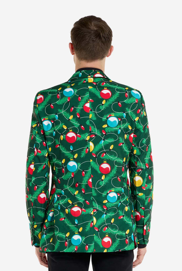 Man met groene kerstblazer voor heren met versierde kerstboomprint. Man draagt ​​ook een zwarte broek en een zwart herenoverhemd. Uitzicht vanaf de achterkant.