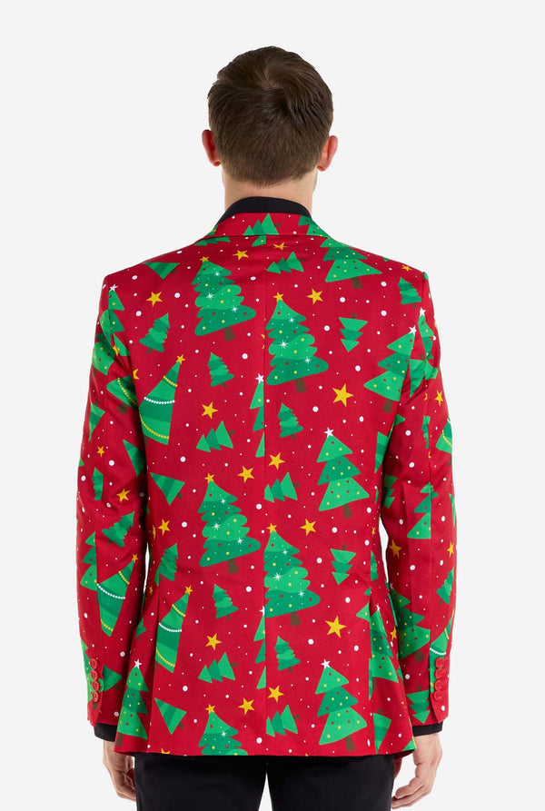 Man met rode kerstblazer voor heren met kerstbomen en sterrenprint. Man draagt ​​ook een zwarte broek en een zwart herenoverhemd. Uitzicht vanaf de achterkant.