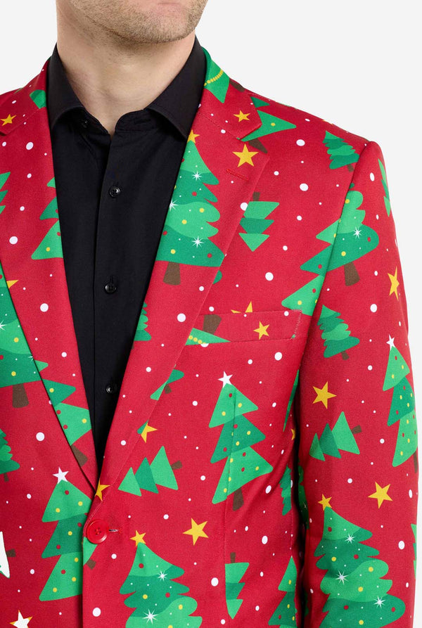Man met rode kerstblazer voor heren met kerstbomen en sterrenprint. Man draagt ​​ook een zwarte broek en een zwart herenoverhemd. Borst close-up.