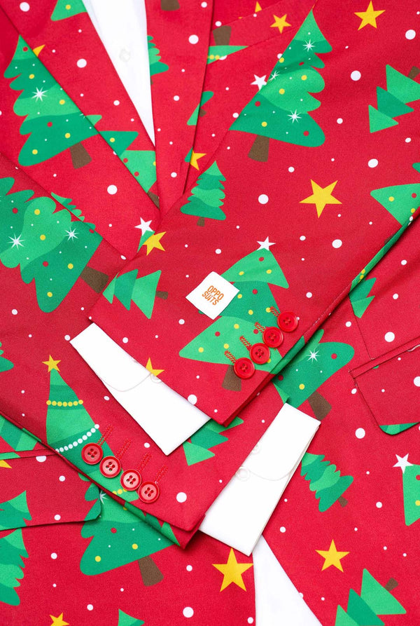 Man met rode kerstblazer voor heren met kerstbomen en sterrenprint. Close-up met wit overhemd.