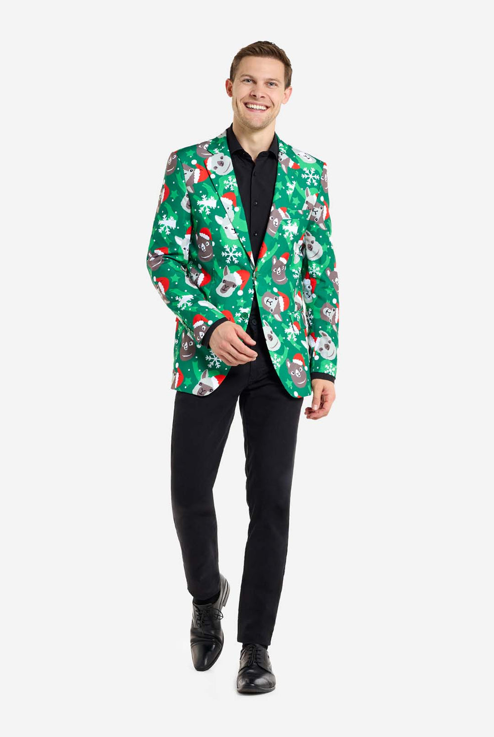 Man met groene kerstblazer voor mannen met kerstlama's. Man draagt ​​ook een zwarte broek en een zwart herenoverhemd.