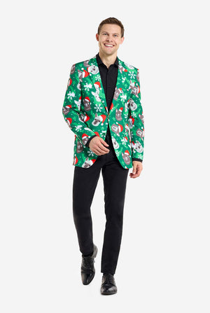 Man met groene kerstblazer voor mannen met kerstlama's. Man draagt ​​ook een zwarte broek en een zwart herenoverhemd. Volledig lichaamsbeeld.