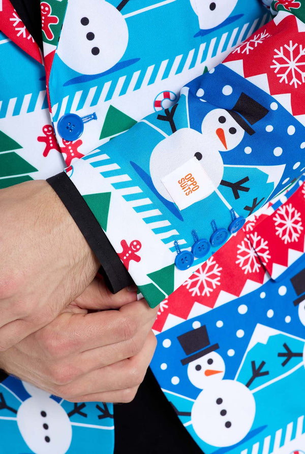 Man met kerstblazer voor mannen met kerstwinterfiguren. Man draagt ​​ook een zwarte broek en een zwart herenoverhemd. Mouw close-up.
