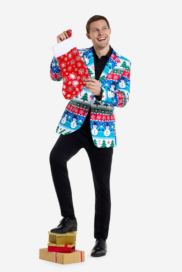 Man met kerstblazer voor mannen met kerstwinterfiguren. Man draagt ​​ook een zwarte broek en een zwart herenoverhemd. Kerstsok vasthouden.