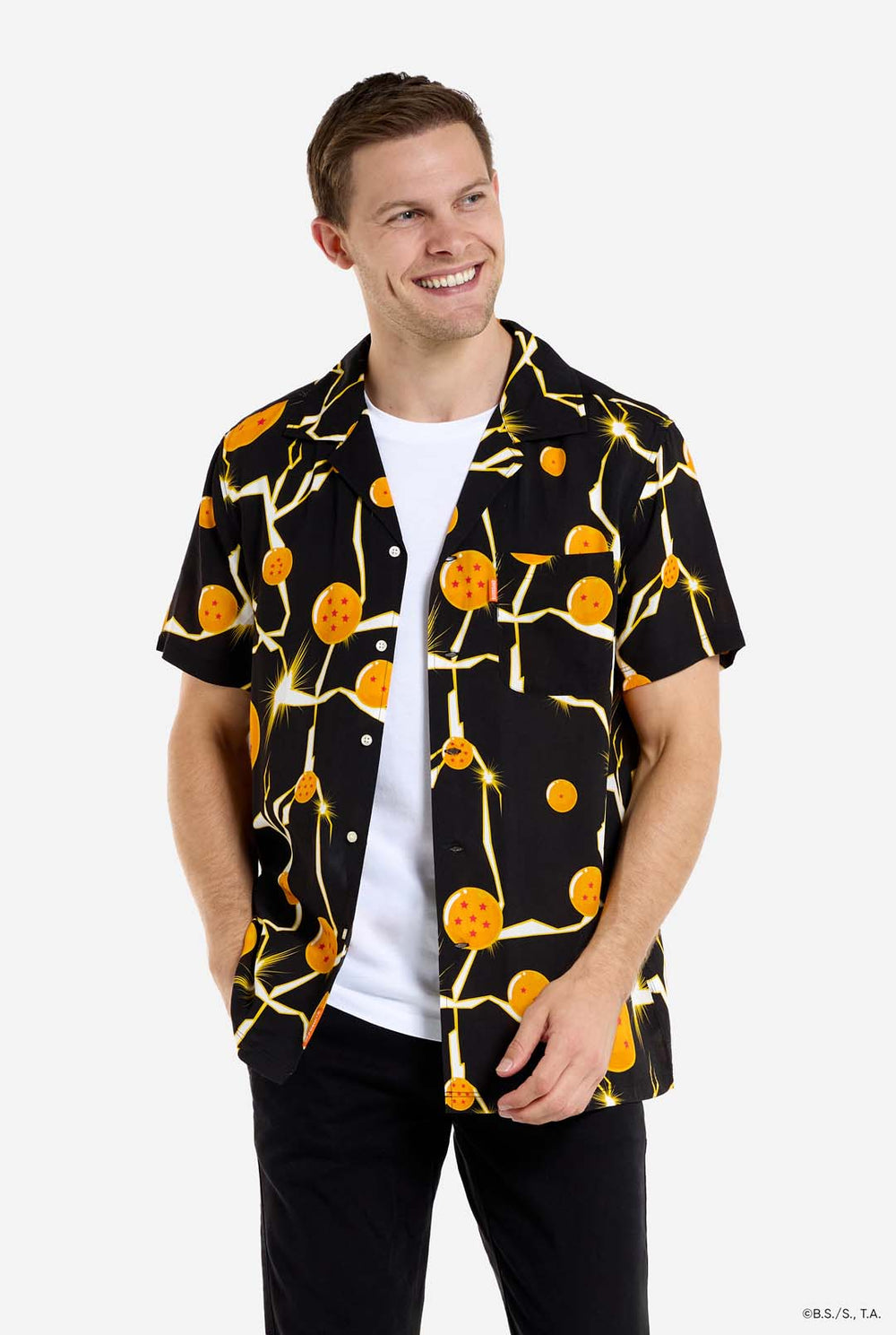 Man in zwart Hawaiiaans shirt met Dragon Ball Z-print, met Dragon Balls en bliksem. Hij draagt ​​ook een wit T-shirt en een zwarte broek.