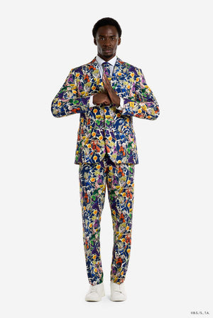 Man draagt ​​een herenpak met een all-over print van Dragon Ball Z, waarop de Dragon Ball-personages staan ​​afgebeeld. Het pak bestaat uit een blazer, een pantalon en een stropdas. Volledig beeld.