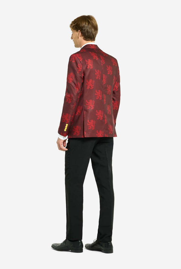 Afbeelding met lichtgrijze achtergrond en een man in een Harry Potter-pak in Griffoendor-stijl. Het pak bestaat uit een rode blazer met Griffoendor-logo en lichtrode leeuwenprint, een zwarte broek en een rood-gele diagonaal gestreepte stropdas. De man toont de achterkant van het pak.