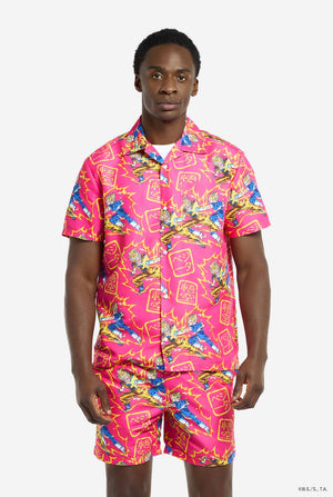 Man draagt ​​roze zomerset bestaande uit shirt en shorts. De zomerset heeft een Dragon Ball Z vechtende Goku en Vegeta print.