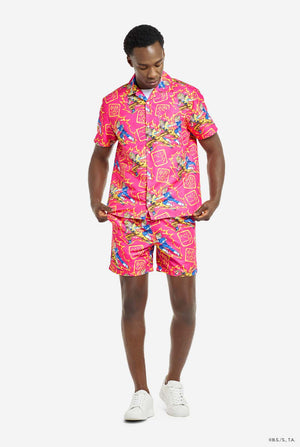 Man draagt ​​roze zomerset bestaande uit shirt en shorts. De zomerset heeft een Dragon Ball Z vechtende Goku en Vegeta print. Compleet beeld