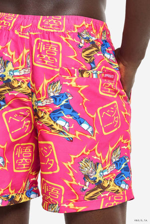 Man draagt ​​roze zomerset bestaande uit shirt en shorts. De zomerset heeft een Dragon Ball Z vechtende Goku en Vegeta print. Achterkant shorts close up.