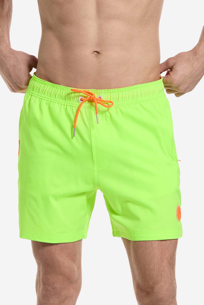 Man draagt neon limoengroene zwembroek voor heren, close up