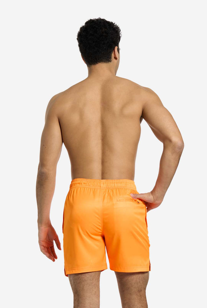 Man wearing Neon Vivid Orange swim trunks for men, view from the back