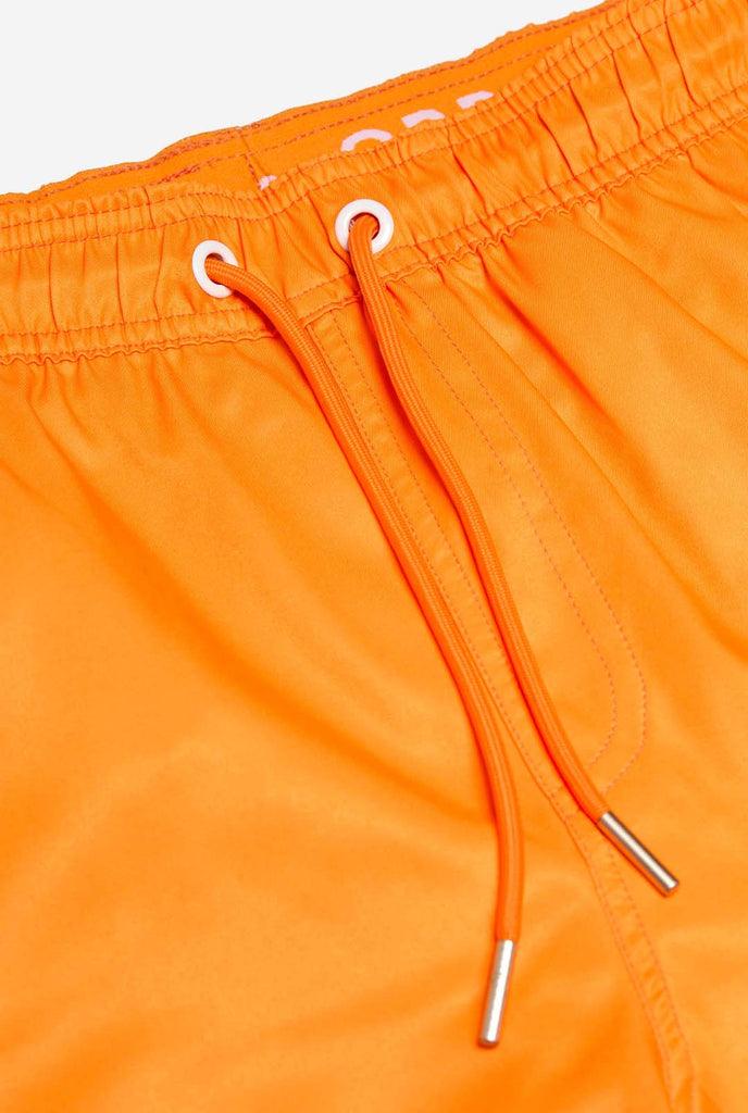 Man wearing Neon Vivid Orange swim trunks for men, close up