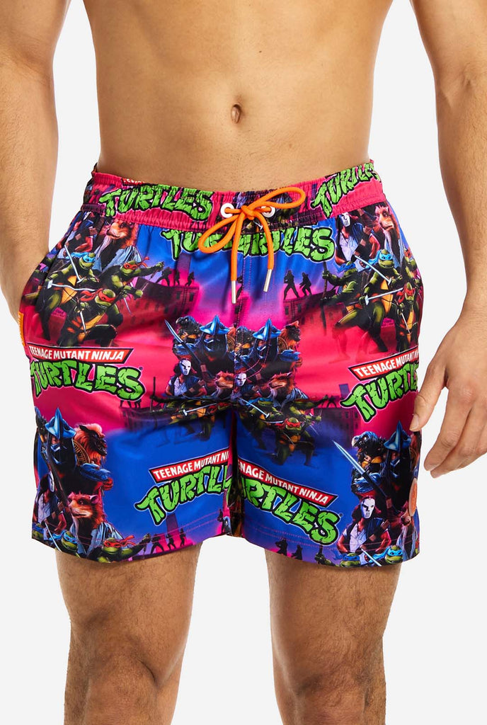 Man wearing TMNT Dude swim trunks for men, close up