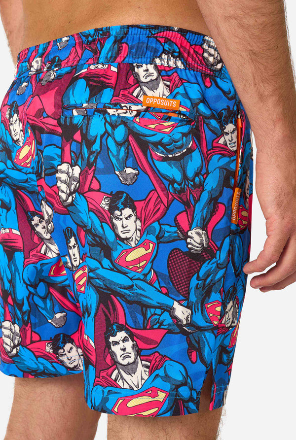 Man draagt ​​een zwembroek met Superman-thema voor heren met een opvallend stripboekontwerp met meerdere actieposes van de Man of Steel. Perfect voor superheldenfans die een spetter willen maken. Close-up achterkant.
