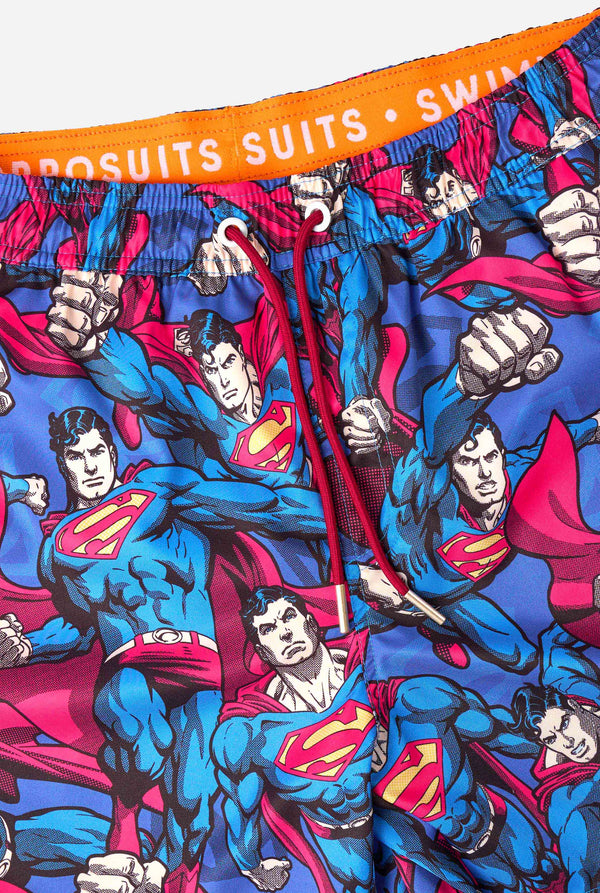 Man draagt ​​een zwembroek met Superman-thema voor heren met een opvallend stripboekontwerp met meerdere actieposes van de Man of Steel. Perfect voor superheldenfans die een spetter willen maken. Close-up drawstrings.