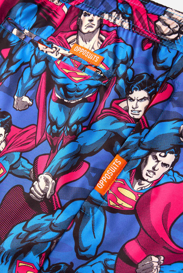 Man draagt ​​een zwembroek met Superman-thema voor heren met een opvallend stripboekontwerp met meerdere actieposes van de Man of Steel. Perfect voor superheldenfans die een spetter willen maken. Close-up ritszakken.