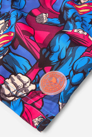 Man draagt ​​een zwembroek met Superman-thema voor heren met een opvallend stripboekontwerp met meerdere actieposes van de Man of Steel. Perfect voor superheldenfans die een spetter willen maken. Close-up patch.