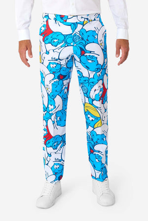 Man gekleed in een kleurrijk herenpak van de Smurfen met een all-over cartoonprint in de kleuren blauw, wit, rood en geel, inclusief bijpassende stropdas en wit overhemd, staande tegen een effen achtergrond. Close up van de broek.