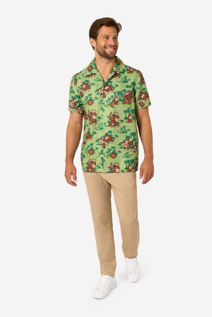 Afbeelding van een man die een Hawaiiaans shirt met Donkey Kong-thema draagt. Het shirt heeft een lichtgroene achtergrond en bevat donkergroene palmbomen, en meerdere afbeeldingen van het personage Donkey Kong, uit Super Mario. De man kijkt naar de zijkant, volledig lichaamsbeeld.