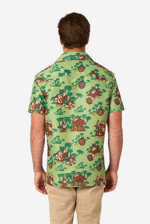 Afbeelding van een man die een Hawaiiaans shirt met Donkey Kong-thema draagt. Het shirt heeft een lichtgroene achtergrond en bevat donkergroene palmbomen, en meerdere afbeeldingen van het personage Donkey Kong, uit Super Mario. Uitzicht vanaf de achterkant.