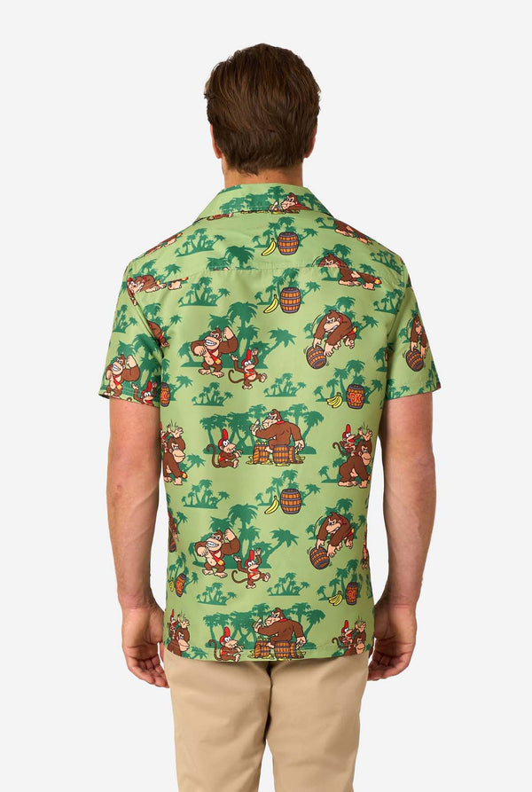 Afbeelding van een man die een Hawaiiaans shirt met Donkey Kong-thema draagt. Het shirt heeft een lichtgroene achtergrond en bevat donkergroene palmbomen, en meerdere afbeeldingen van het personage Donkey Kong, uit Super Mario. Uitzicht vanaf de achterkant.