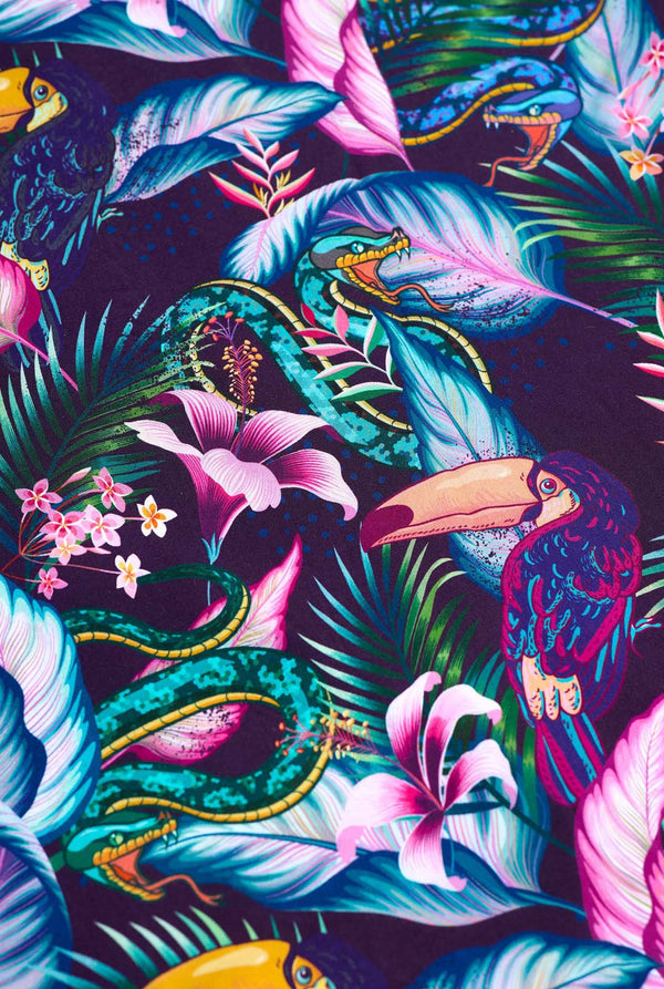 Een paars Hawaiiaans shirt met een tropische print, die doet denken aan het nachtleven in de jungle. De print bestaat uit papegaaien, slangen, bladeren en bloemen. 