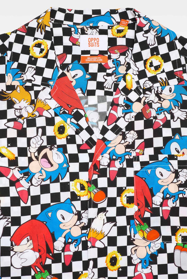 Close-up van een zwart-wit geruit Hawaiiaans shirt met personages uit de Sonic the Hedgehog-franchise en gouden ringen erop.