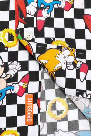 Close-up van een zwart-wit geruit Hawaiiaans shirt met personages uit de Sonic the Hedgehog-franchise en gouden ringen erop. Laat het onderste deel van het shirt zien.