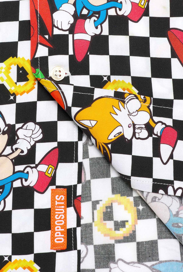 Close-up van een zwart-wit geruit Hawaiiaans shirt met personages uit de Sonic the Hedgehog-franchise en gouden ringen erop. Laat het onderste deel van het shirt zien.