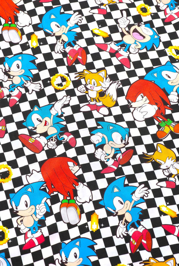 Close-up van een zwart-wit geruit Hawaiiaans shirt met personages uit de Sonic the Hedgehog-franchise en gouden ringen erop. Toont de print met verschillende karakters zoals: Sonic, Knuckles, Tails en gouden ringen.