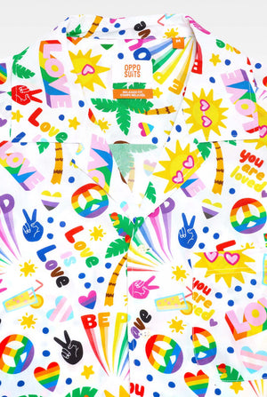 Foto van ​​een wit Hawaiiaans shirt met een regenboogprint. De print bestaat uit vredessymbolen, hartjes en andere iconen. 