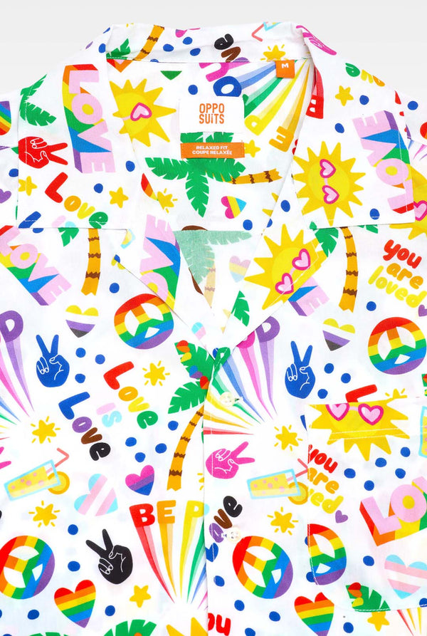 Foto van ​​een wit Hawaiiaans shirt met een regenboogprint. De print bestaat uit vredessymbolen, hartjes en andere iconen. 