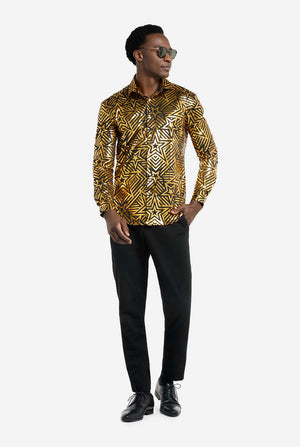 Deze afbeelding toont een herenoverhemd van OppoSuits met een levendig goud- en zwart geometrisch sterrenprintpatroon. Het shirt heeft een reflecterende afwerking die de ingewikkelde ster- en lijnontwerpen benadrukt, waardoor een dynamische en stijlvolle look ontstaat. Dit overhemd is perfect voor degenen die willen opvallen. Het is zowel stoer als modieus, ideaal voor feestjes, feestdagen of het nachtleven. Het model draagt ​​het gecombineerd met een zwarte broek en een zonnebril.