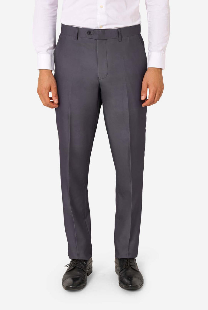 Een man draagt ​​een stijlvol antracietgrijs pak met een wit overhemd en ziet er zelfverzekerd uit. Perfecte formele outfit voor speciale gelegenheden, bruiloften en feesten. Close-up broek.