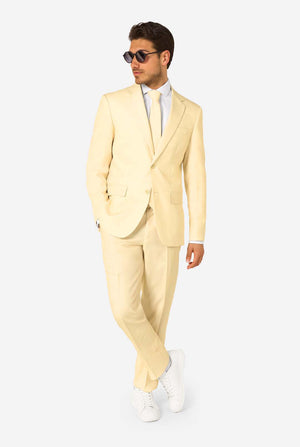 Elegant herenpak in een zachte pastelgele tint, perfect voor bruiloften, zomerse evenementen en formele gelegenheden. Dit stijlvolle maatpak heeft een slim fit, inkepingen in de revers en een bijpassende stropdas voor een verfijnde look. Ideaal voor moderne heren die een statement willen maken met een licht pastelkleurig pak. Volledig beeld en draagt zonnebril.