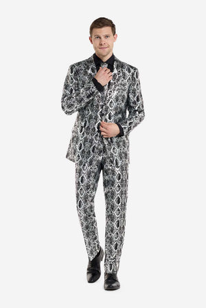 Een man draagt ​​een opvallend zilver-zwart pak met slangenprint van OppoSuits en zwarte schoenen. Het opvallende pak heeft een opvallend slangenpatroon en biedt een strakke, modieuze look, perfect voor feestjes, evenementen of voor het maken van een gedurfd modestatement. Het herenpak wordt gecombineerd met een zwart overhemd en een bijpassende stropdas met slangenprint, wat een verfijnd tintje toevoegt aan het geheel.