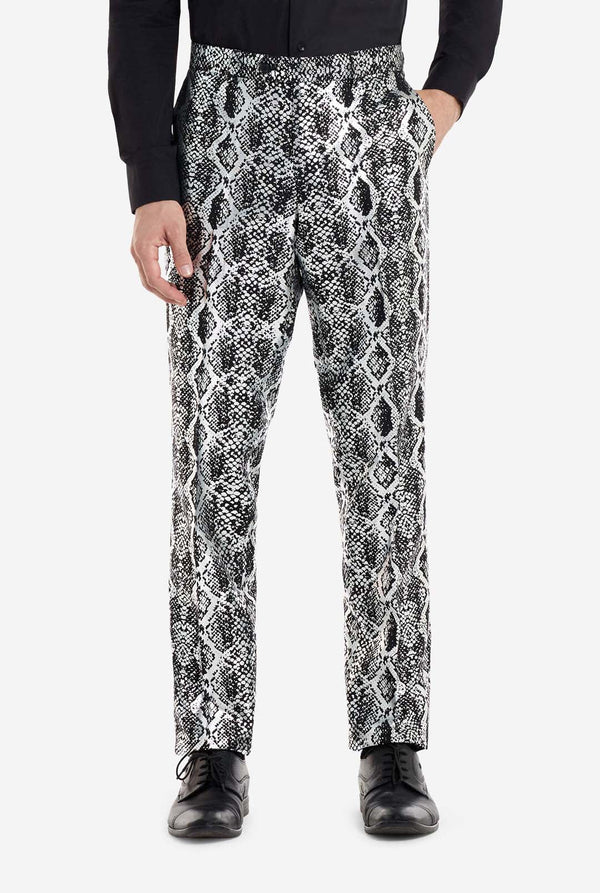 Een man draagt ​​een opvallend zilver-zwart pak met slangenprint van OppoSuits. Het opvallende pak heeft een opvallend slangenpatroon en biedt een strakke, modieuze look, perfect voor feestjes, evenementen of voor het maken van een gedurfd modestatement. Het herenpak wordt gecombineerd met een zwart overhemd en een bijpassende stropdas met slangenprint, wat een verfijnd tintje toevoegt aan het geheel. Close-up van de broek.