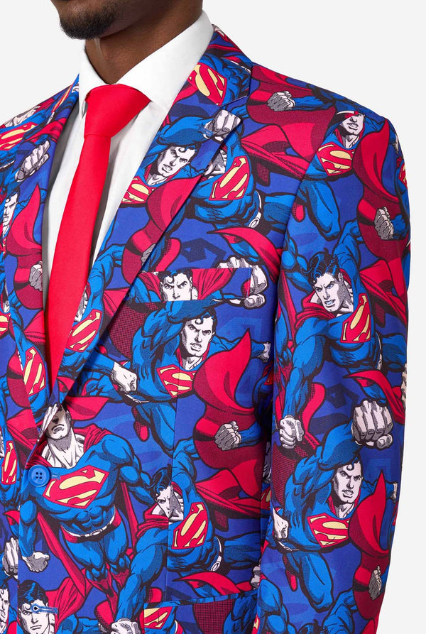 Een man draagt een pak met Superman-thema, een rode stropdas en een wit overhemd op een witte achtergrond. Close up van de borst