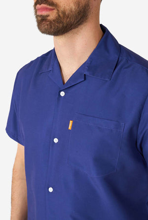 Man met blauwe zomerset bestaande uit shirt en korte broek, close-up op de borst