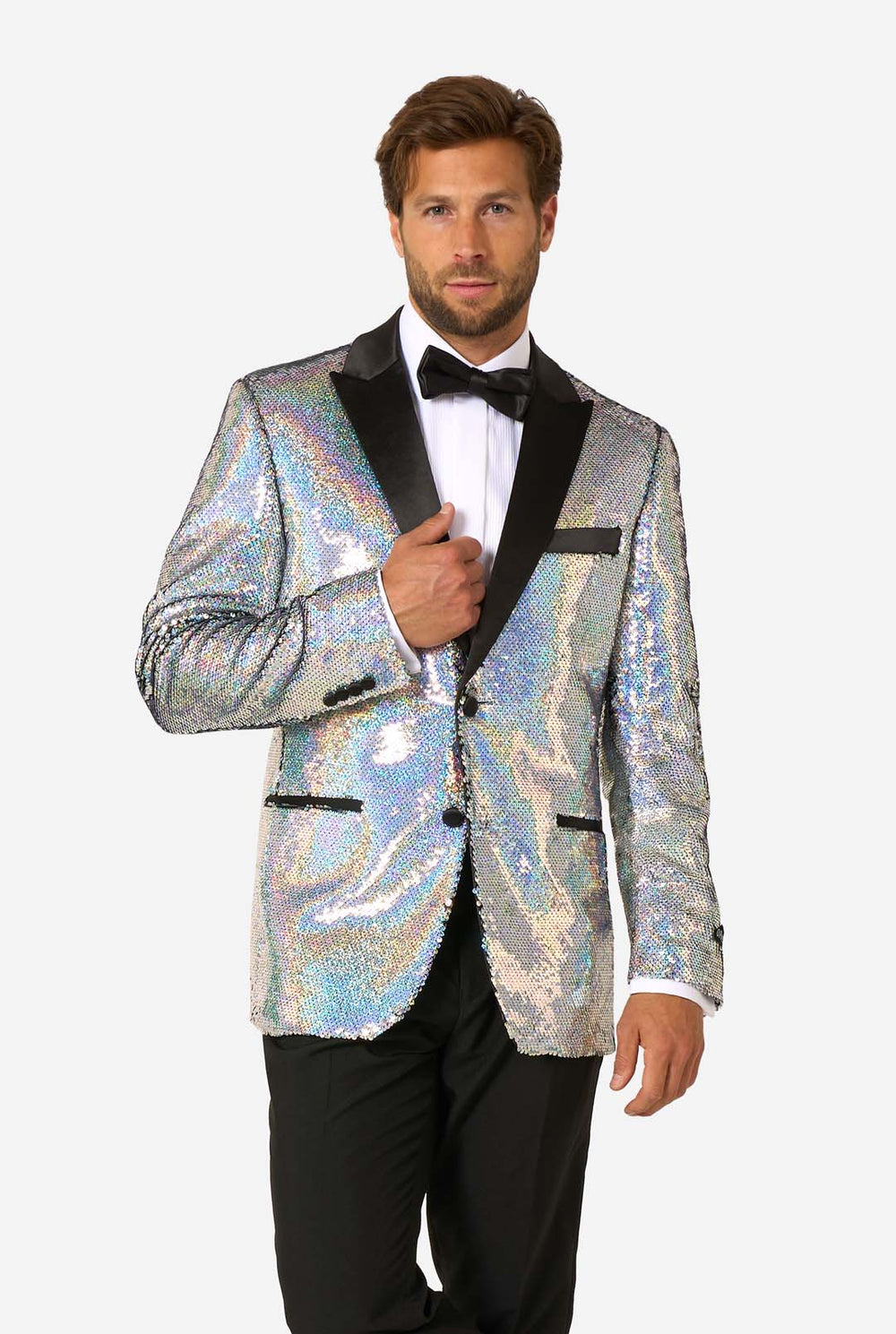 Man in sequin smoking met holografische zilveren pailletten en zwarte satijnen revers, gecombineerd met een wit overhemd, zwarte vlinderdas en zwarte broek.