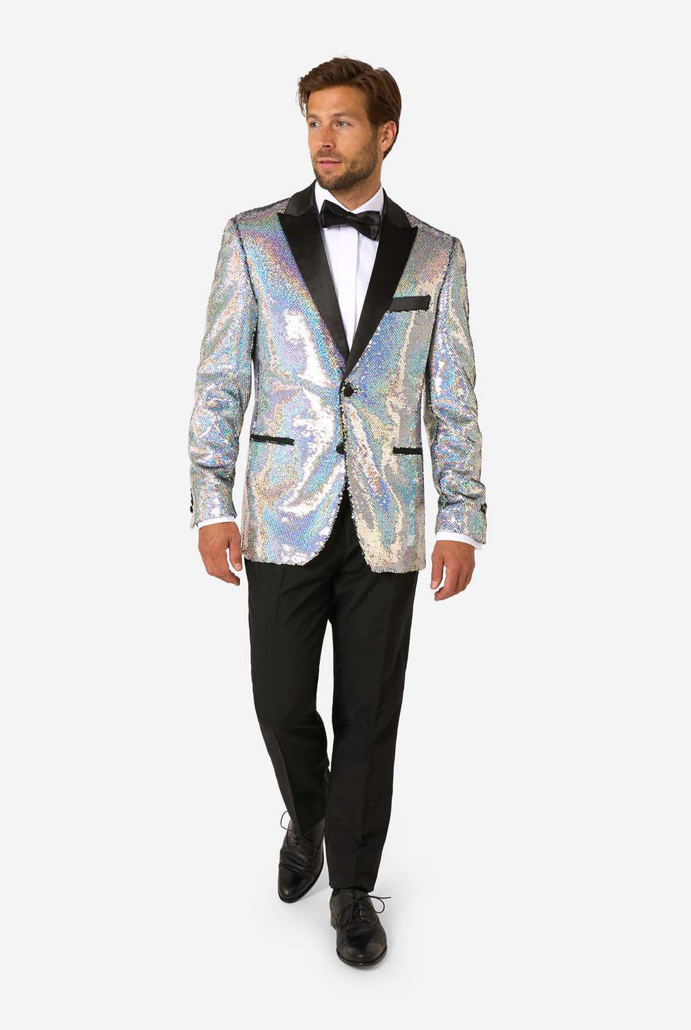 Man in sequin smoking met holografische zilveren pailletten en zwarte satijnen revers, gecombineerd met een wit overhemd, zwarte vlinderdas en zwarte broek.