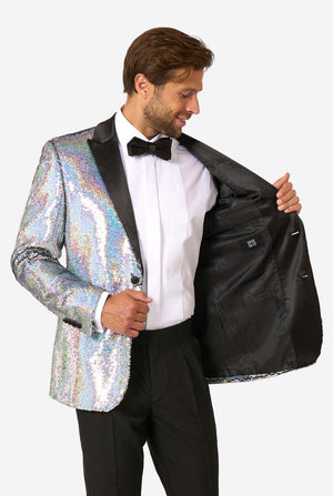 Man in sequin smoking met holografische zilveren pailletten en zwarte satijnen revers, gecombineerd met een wit overhemd, zwarte vlinderdas en zwarte broek.