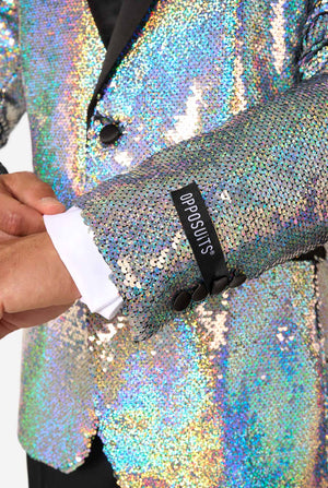 Man in sequin smoking met holografische zilveren pailletten en zwarte satijnen revers, gecombineerd met een wit overhemd, zwarte vlinderdas en zwarte broek. Close-up beeld.